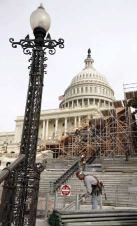 Workers build the inaugural platform in front of the Capitol ...