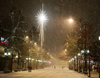 A giant star on a Macy's store shines as heavy snow falls late ...