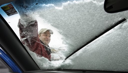 Brad Sinko clears snow from his windshield after making a cheese ...